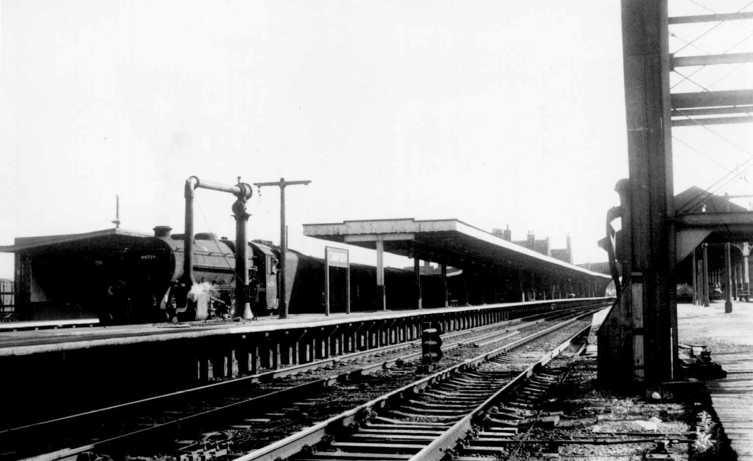 Circa 1966. "Black Five" 44737 (?) is standing at the Barrow platform, at Carnforth, with a departure to the south. The tender is piled high with coal, which suggests that the locomotive may be just starting its days work. H.C.Casserley