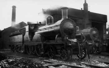 1912. Furness Railway locomotive shed with Furness Railway 4-4-0 No. 127. Later design of 4-4-0 stands beyond. Kelland Collection.